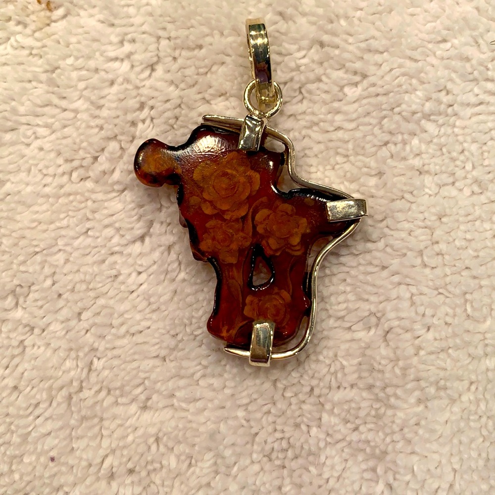 Amber pendant with flowers set in silver.